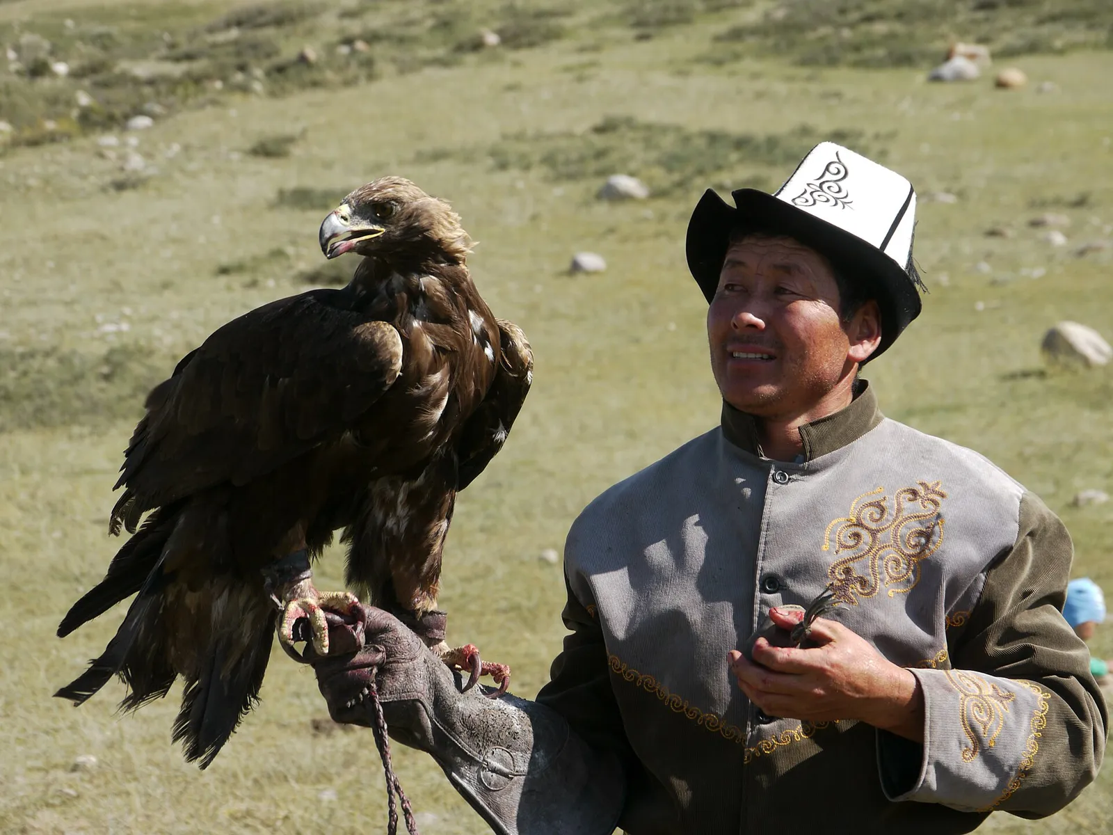 An eagle hunter with his golden eagle on the southern shore of Issyk-Kul